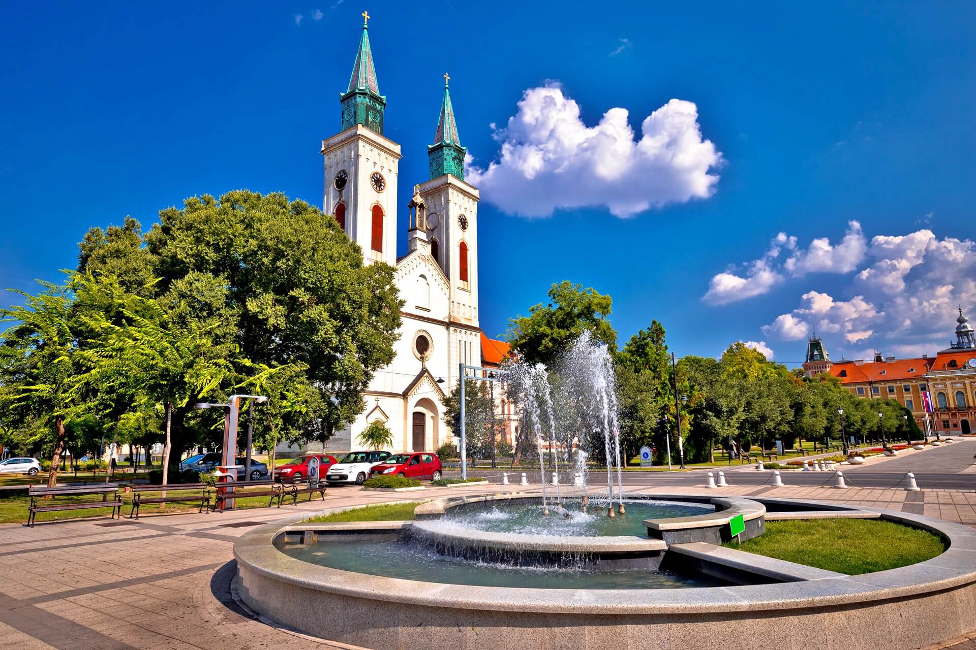 Kyrka och fontän i Sombor gatasikt